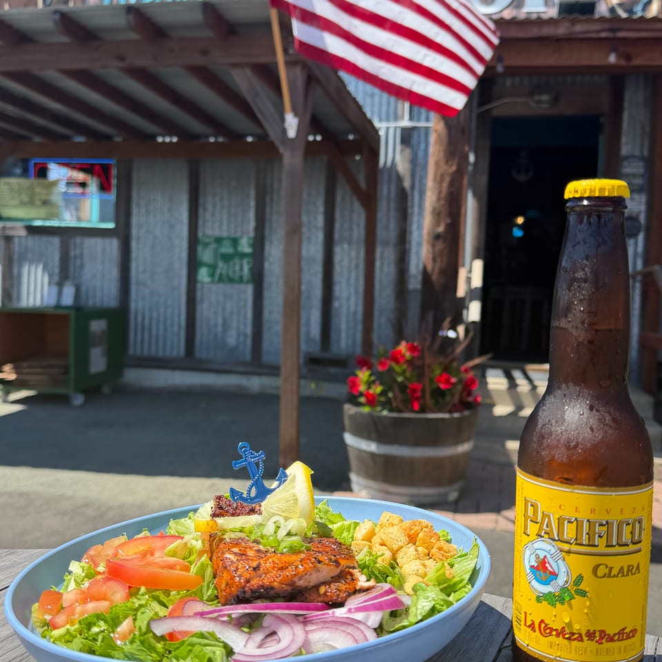 Grilled fish salad and Pacifico beer on an outdoor table at The Anchor restaurant.